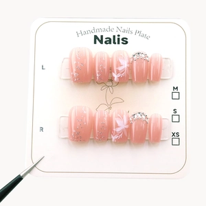 Handmade nude pink press-on nails with white flower painting and sparkling rhinestones