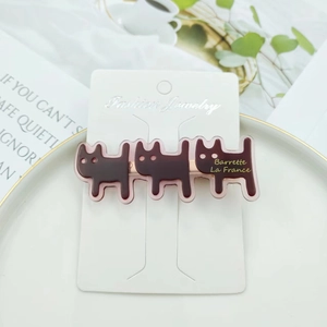 Minimalist acetate cat hair clips in dark brown with three kitty shapes on a card