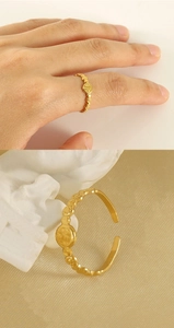 Détail d'une bague pièce d'or ajustable avec texture vintage et vue sur la main du mannequin
