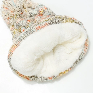 Detail of soft white fleece lining inside a colorful mixed knit winter beanie with pompom