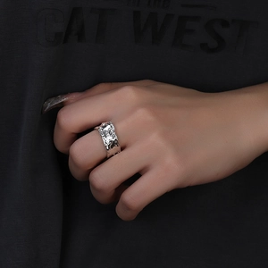 Detailed view of silver wide ring with irregular molten metal texture worn on index finger