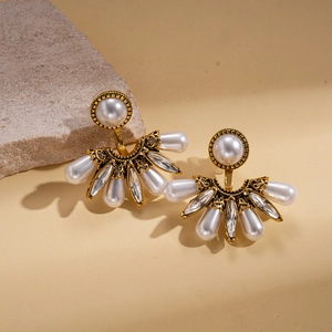 Détail de boucles d'oreilles baroques en éventail avec perles et cristaux sur pierre