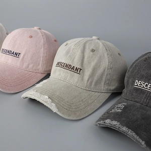 Close-up of DESCENDANT embroidery and distressed brim on cotton baseball caps