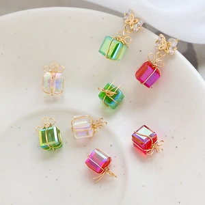 Macro shot of colorful cube crystal earring charms wrapped in gold wire with bows