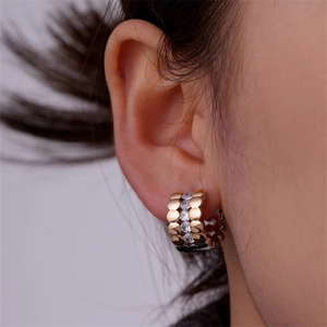 Macro side view of rose gold twisted hoop earrings with crystal pavé on a model