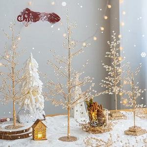 Golden bead Christmas tree decorations with wooden bases in a festive snowy scene