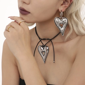 Hammered silver heart earrings and necklace set on black cord shown on a model