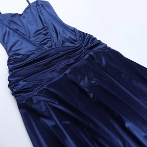 Vue détaillée de la texture du tissu en satin bleu foncé et des plis de la robe longue