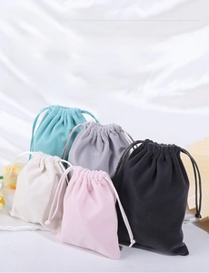 Detailed view of plush drawstring jewelry pouches in mint, grey, beige, pink and black
