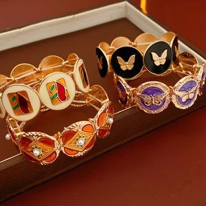 Detail of vintage enamel butterfly bracelets with pearl inlays on a jewelry tray
