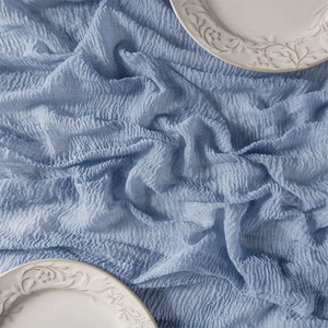 Detailed close-up of blue boho cheesecloth table runner with soft pleated texture