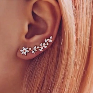 Close-up of rose gold ear crawler with marquise cut zircons in floral leaf design