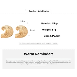 Detail showing wavy gold-tone C-shaped earrings with alloy texture and size dimensions