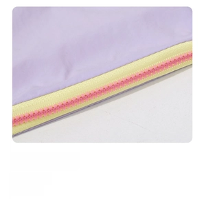 Detail of smooth colorful contrasting zipper on lavender portable makeup bag