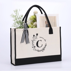Detail of canvas tote bag with black summer vibe floral wreath and initial C print