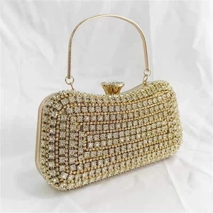 Close-up of evening clutch bag featuring rhinestones, gold handle and crystal clasp