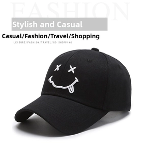 Detailed close-up of white smiling face embroidery on a black cotton baseball cap