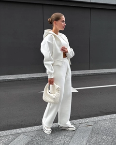 Détail d'un survêtement blanc deux pièces avec sweat à capuche court et pantalon large