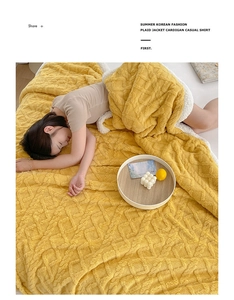 Detail of yellow waffle velvet blanket with thick white sherpa lining on a cozy bed