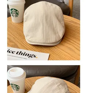 Detailed macro view of the apricot textured striped newsboy cap on a wooden table
