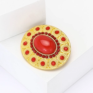 Vintage gold oval brooch with large red stone centerpiece and surrounding ruby crystals