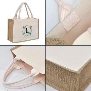 Detail view of jute tote bag showing pink handles, stitching and letter L floral print