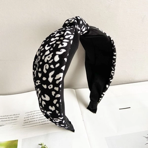 Detailed close-up of a wide leopard print headband with a stylish central knot design