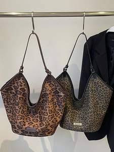 Fashionable leopard print tote bags in brown and olive green displayed on a hanger