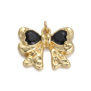 Macro shot of gold bow pendant with black heart gems and textured ribbon detail