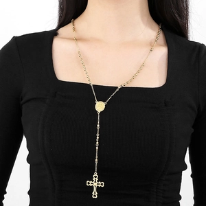 Detailed view of 6mm gold bead necklace with vintage cross pendant on black clothing