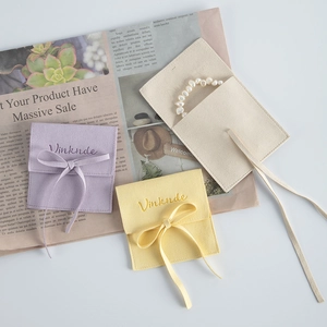 Detailed view of microfiber velvet jewelry pouches in purple, yellow, and beige colors