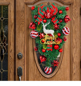 Detail of Christmas wreath with white reindeer, red berries and gold Merry Christmas sign