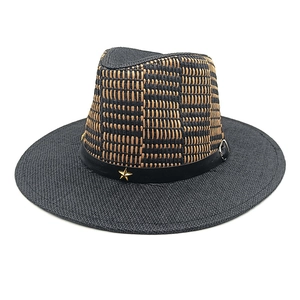 Detail of two-tone straw fedora with black brim and gold star metal emblem