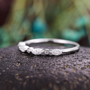 Makroaufnahme von Marquise- und Rundschliff-Diamanten auf einem silbernen Stapelring
