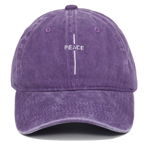 Detail of embroidered PEACE logo on vintage washed purple cotton baseball cap