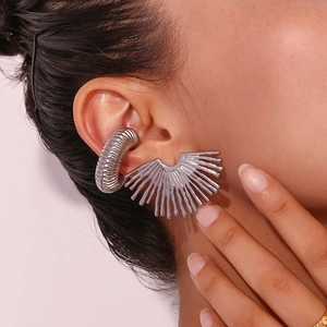 Detail of silver sunburst fan stud earring and twisted ear cuff on model ear