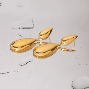 Close-up of golden teardrop earrings with smooth metallic finish and water drop decor