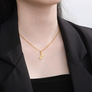 Close-up of gold-plated stainless steel double heart pendant necklace on a female neck