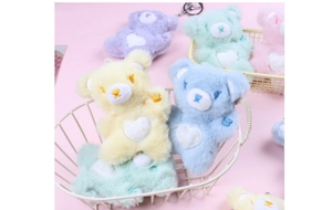 Detailed close-up of colorful plush bear keychains in yellow blue green and purple colors