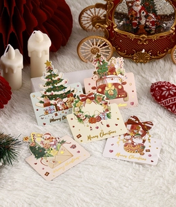 Detailed view of gold foil Christmas greeting cards with Merry Christmas text on white fur