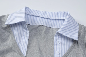Detailed close-up of grey knit dress with blue striped collar and white buttons