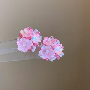 Detail of handmade pink beaded flower earrings with delicate tassel and silver needle