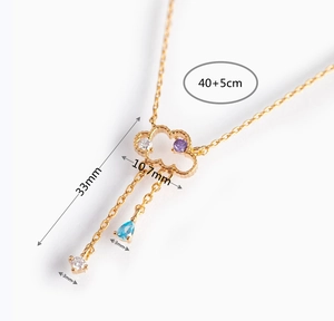 Close-up of gold cloud necklace with colorful zircons and size measurements 40+5cm