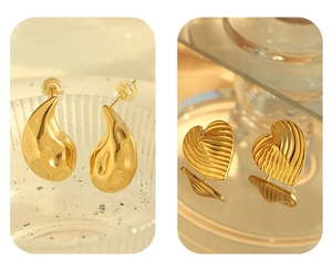 Macro detail of French gold earrings featuring waterdrop and heart textures