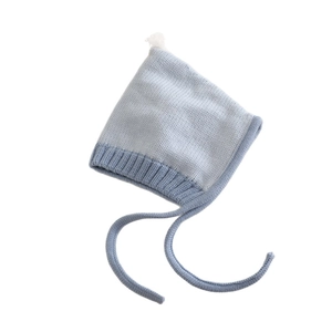 Knit baby winter hat with pointed top, pompom and earflaps in colorblock blue