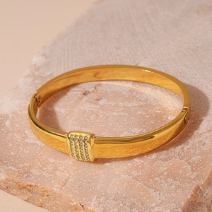 Detail eines goldenen Edelstahl-Armbands mit Reihen aus Zirkonia-Steinen besetzt