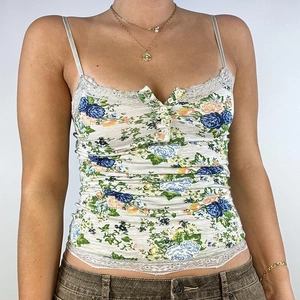 Close-up of floral camisole showing delicate lace trim and front button detail