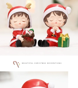 Gros plan de deux figurines de Noël en résine rouge avec bonnets et bois de renne