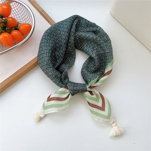 Detailed view of dark green scarf with pink letters, tassels, and tri-color stripe edges