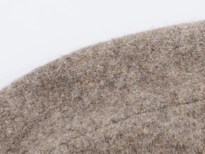 Detailed close-up showing the soft textured fabric and warm fibers of the knitted cardigan